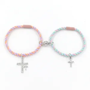 Bracelets de couple tressés magnétiques avec pendentifs croix en strass sur blanc