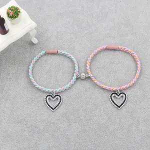 Detail of magnetic braided friendship bracelets with macaron colors and heart charms