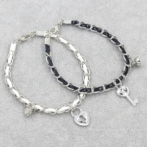 Magnetic couples bracelet set with black and white braided ropes and heart lock charm