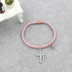Détail de bracelets tressés orange et violet avec fermoir magnétique et croix en cristal