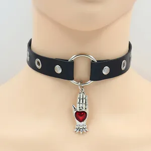 Makroansicht des Punk-Lederhalsbands mit silbernen Nieten und Herz-Hand-Anhänger