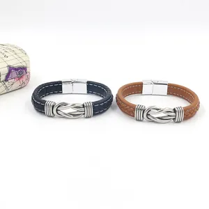 Detail of woven black and brown leather bracelets with polished metal magnetic clasps