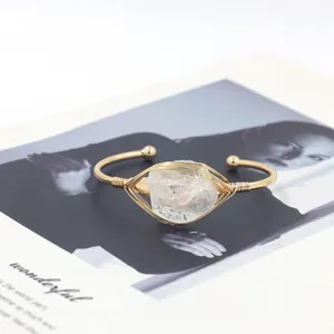 Verstelbare goudkleurige wikkelarmband met een ruwe witte kwarts edelsteen