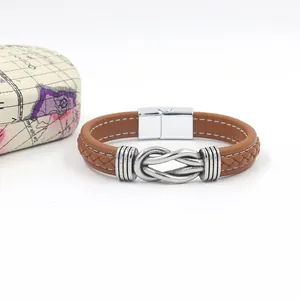 Detail of a brown woven leather bracelet with vintage metal knot and magnetic clasp