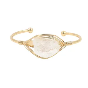 Open armband met onregelmatig wit kristal en goudkleurig omwikkeld metaalontwerp