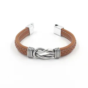 Close-up of brown braided leather bracelet with silver magnetic alloy buckle and stitching