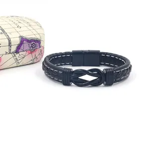 Detail of black braided leather bracelet with magnetic clasp and decorative metal knot