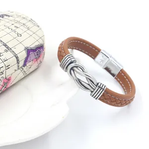 Detail of woven brown leather bracelet with vintage silver nautical knot and magnetic clasp
