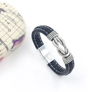 Detail of black braided leather bracelet with silver infinity knot and magnetic clasp