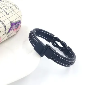 Detail of black braided leather bracelet with infinity knot and map gift box