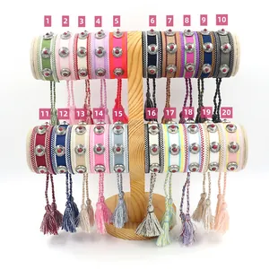 Detailed view of twenty colorful bohemian woven friendship bracelets with metal studs