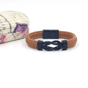 Macro detail of brown leather bracelet featuring white stitching and black magnetic clasp