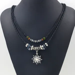 Ethnic double-layered woven necklace with beads and sun pendant on black bust