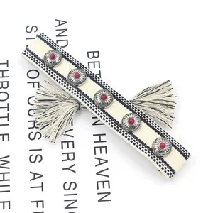 Bohemian woven friendship bracelet with silver studs, red beads and black tassels