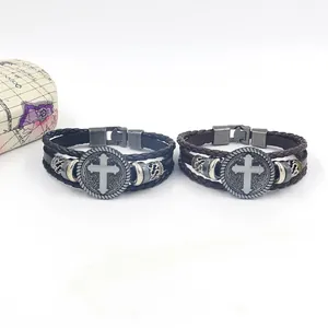 Detail view of woven leather bracelets with vintage alloy cross charm and metal buckle