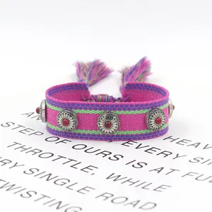 Detail of bohemian woven friendship bracelet with vintage metal studs and tassels