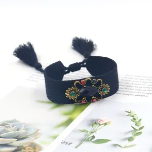 Detalle de pulsera tejida vintage con detalles de gemas y elegantes borlas de color negro