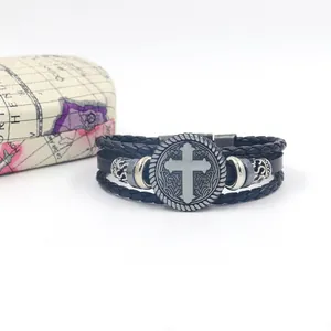 Detail of multi-layer leather bracelet with cross emblem and vintage magnetic clasp