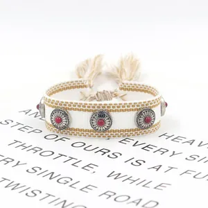 Bohemian hand-woven friendship bracelet with metal studs, red beads and fringe tassel cord