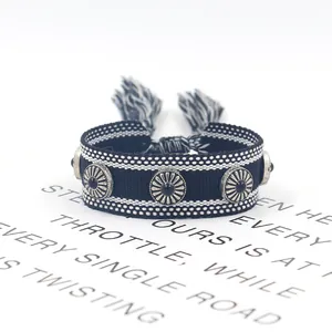 Detalle de pulsera trenzada con piedras negras, tachuelas de plata antigua y borlas