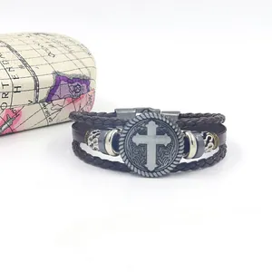 Detail of multi-layer leather bracelet with vintage metal cross charm and clasp
