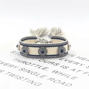 Pulsera bohemia de algodón blanco con tachuelas de plata y borlas decorativas