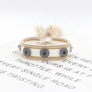 Detalle de pulsera tejida a mano con patrón étnico y dijes de cuentas azules finas