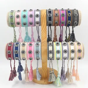 Pulseras trenzadas bohemias con tachuelas de metal en un soporte de madera