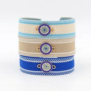 Macro detail of hand-woven friendship bracelets with rhinestone evil eye metallic charms