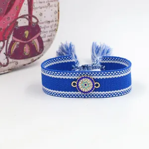 Detailed view of woven Evil Eye friendship bracelet with sparkling blue rhinestones