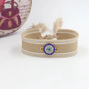 Detailed view of woven Evil Eye friendship bracelet with blue rhinestone metal charm