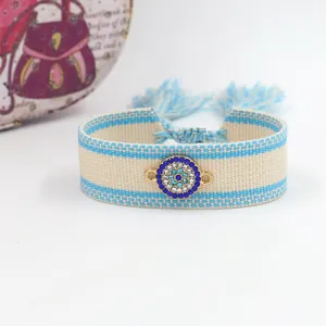 Detailed shot of evil eye woven bracelet with blue rhinestones and fringe drawstring