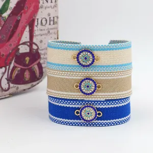 Detailed view of three woven Evil Eye bracelets with colorful embroidery and crystals