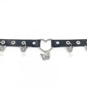 Dettaglio choker in pelle con anello a cuore, ciondolo a farfalla e perle