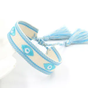 Macro detail van Boheemse geweven armband met Evil Eye borduursel en blauwe kwastjes