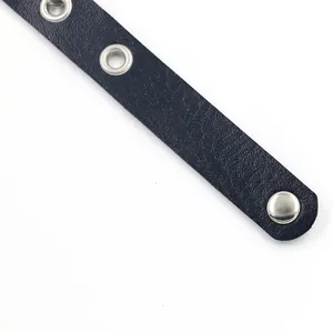 Dettaglio del cinturino in pelle blu scuro con occhielli argento e bottone a scatto