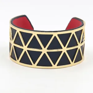 Detail of gold geometric hollow cuff bracelet with black leather and red lining