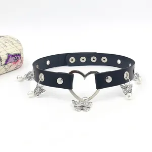 Dettaglio choker in pelle nera con cuore in metallo argento, farfalle e perle pendenti