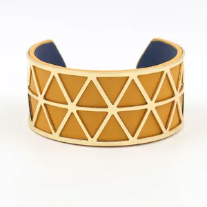 Detail of wide gold hollow triangle bracelet with reversible yellow and blue leather