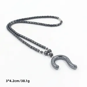 Detail van de hematiet kralenketting met 3x4,2 cm U-vormige geometrische hanger