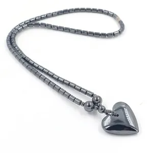 Donkergrijze hematiet kralenketting met gepolijste hart hanger op witte achtergrond