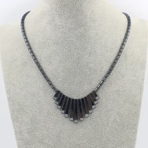 Gepolijste zwarte hematiet kralenketting met waaiervormige hanger op een nekmodel display