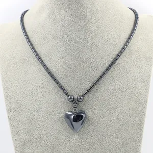 Minimalistische donkergrijze hematiet kralenketting met gepolijste hart hanger op etalagepop