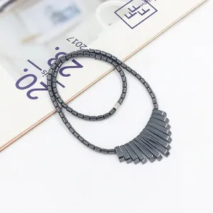 Minimalistische hematiet kralenketting met geometrische waaiervormige hanger op tijdschrift