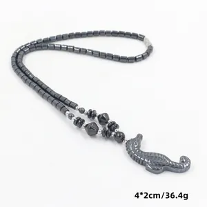 Detail van donkere hematiet kralenketting met een zeepaardje hanger en afmetingen