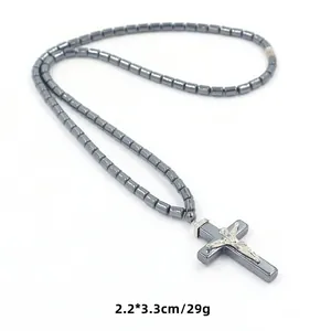 Detailweergave van grijze hematiet kralen en zilveren crucifix kruis hanger aan de ketting