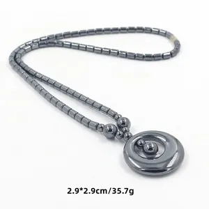 Detail van hematiet kralenketting met 2,9 cm ronde hanger en afmetingen getoond