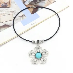 Detail of bohemian black leather cord necklace featuring a hollow metal flower pendant