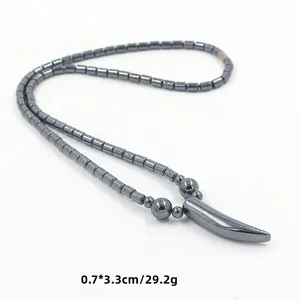 Detail van donkergrijze hematiet kralenketting met hoornen hanger van 0,7 x 3,3 cm