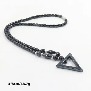 Detail van hematiet kralenketting met een 3x3cm geometrische driehoekige hanger
